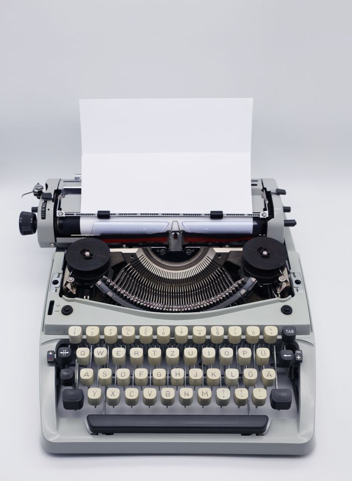 Classic typewriter with blank paper, ideal for retro and vintage themes.